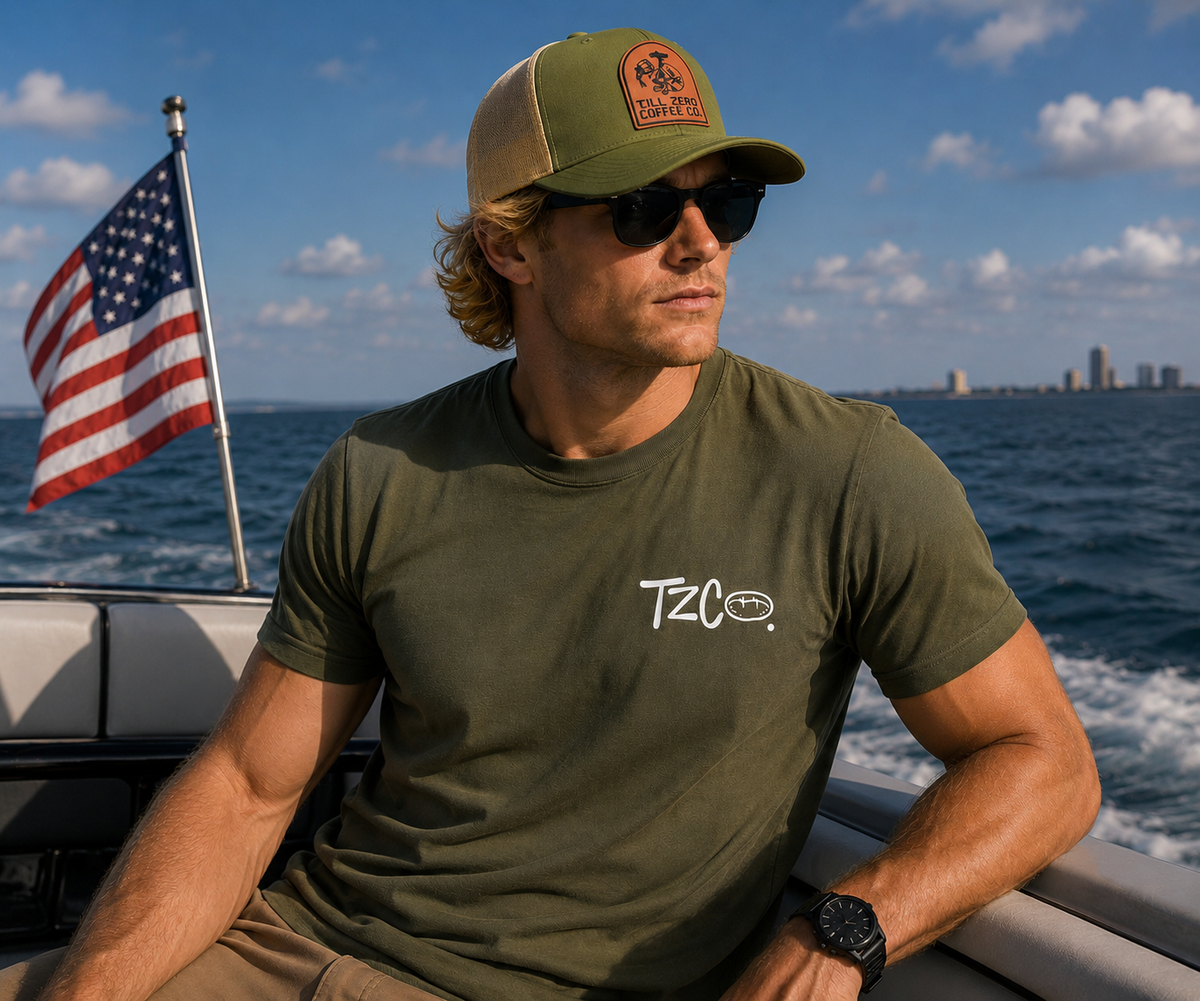 Till Zero Coffee Co. tee in olive, worn, showing the TZCO chest wordmark